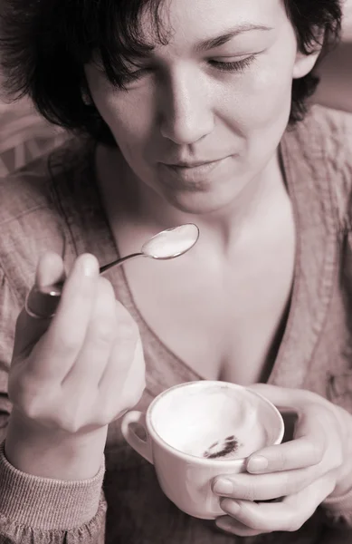 Vrouw genieten van een cappuccino — Stockfoto