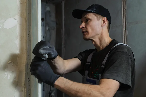 Woker fixiert eine Anleitung, um die Wände mit Stuck auszurichten — Stockfoto