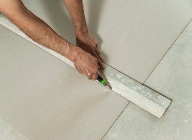 Adam drywall bir parça keser