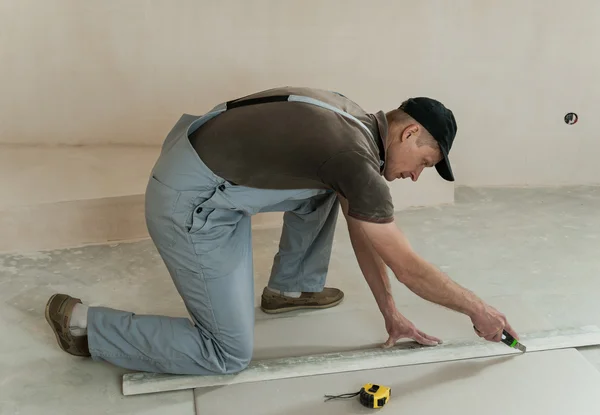 Worker cuts a piece of drywall — Stock Photo, Image