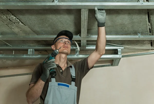 Worker assembles metal frame — Stock Photo, Image