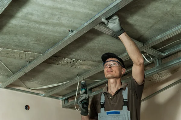 Worker assembles profile metal frame — Stock Photo, Image