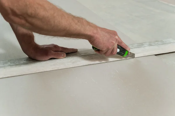 Homem corta um pedaço de drywall — Fotografia de Stock