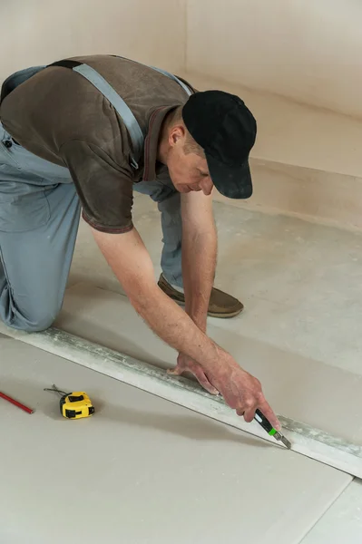 Arbeiter schneidet ein Stück Trockenbau — Stockfoto