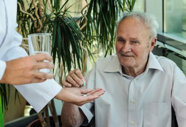 Elderly man takes medication clipart