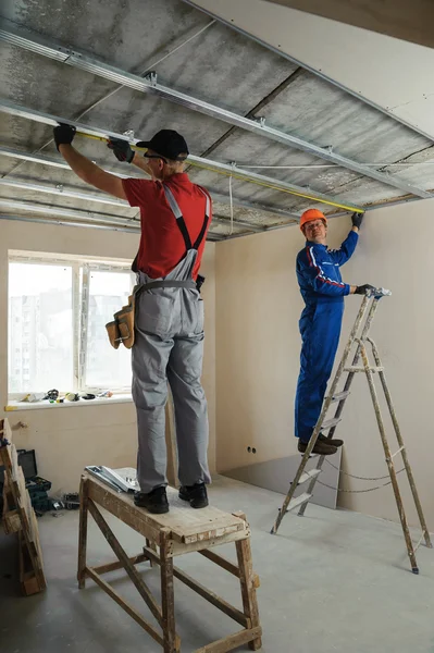 I lavoratori misurano telaio in metallo — Foto Stock