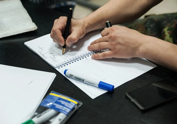 Hand man neemt notities in een notitieblok — Stockfoto