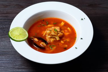 Siyah arka plan üzerine midye ile lezzetli çorba