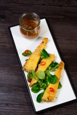 Kızarmış Mozzarella peyniri domates sosu ile yeşillik servis yapışıyor