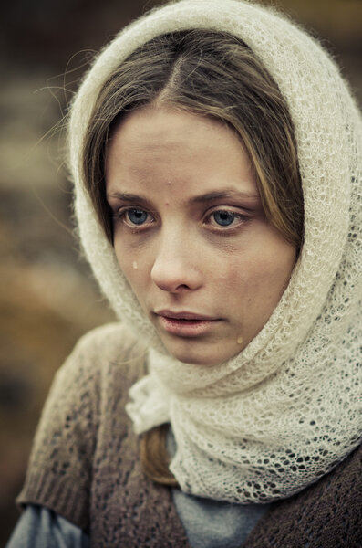 молодая девушка, одетая в бедный свитер и шарф
