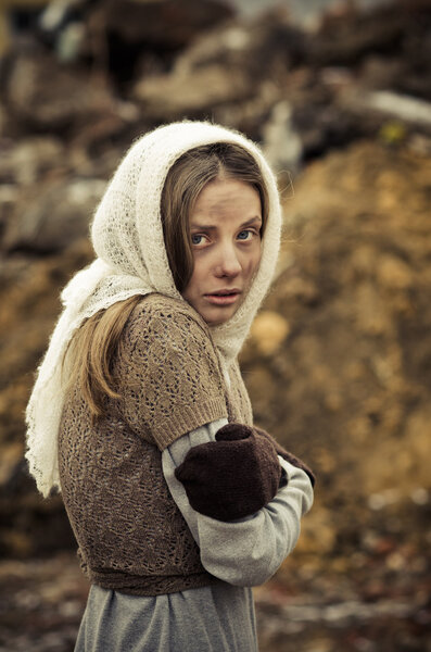 молодая девушка, одетая в бедный свитер и шарф
