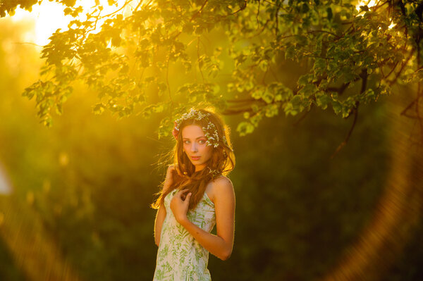 Young elegant lady in the bright dress, in the sunset.