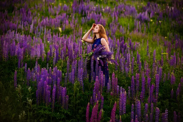 Chica en un campo de flores silvestres púrpura — Foto de Stock
