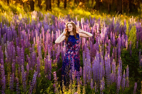 Flicka i ett fält av lila blommor — Stockfoto