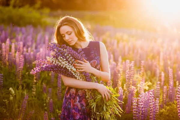 Dziewczyna w dziedzinie purpurowe kwiaty, zachód słońca na słoneczny dzień — Zdjęcie stockowe