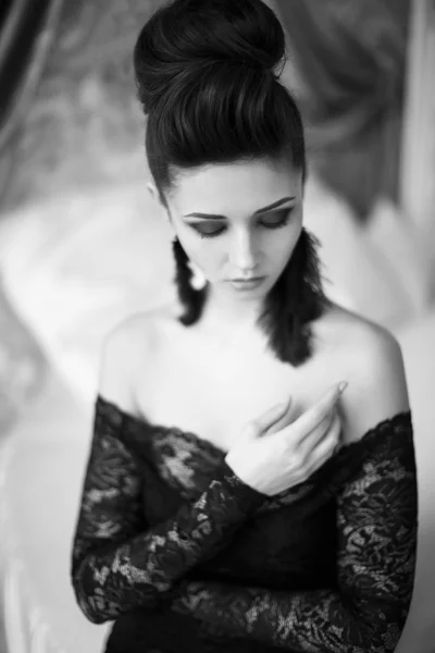 Modelo bonito em vestido preto com maquiagem à noite e penteado posando — Fotografia de Stock