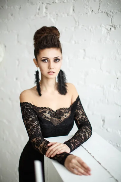 Modelo bonito em vestido preto com maquiagem à noite e penteado posando — Fotografia de Stock