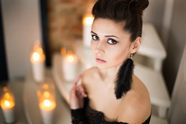 Modelo bonito em vestido preto com maquiagem à noite e penteado posando — Fotografia de Stock