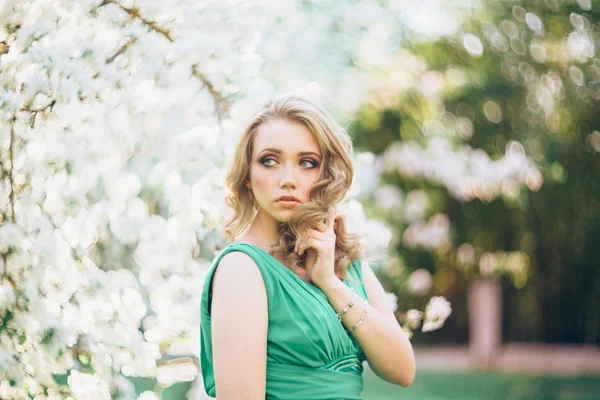 Hermosa mujer joven feliz en el jardín floreciente primavera — Foto de Stock