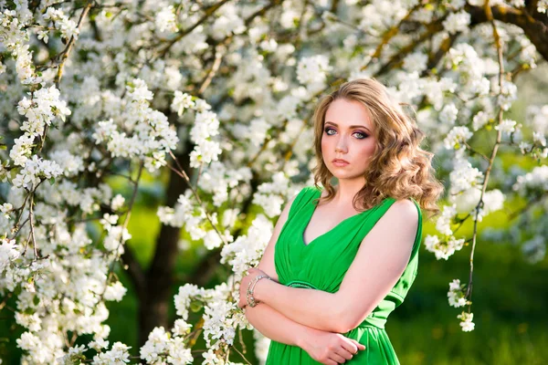 Mooie blonde vrouw in een bloeiende tuin van appelbomen mode — Stockfoto