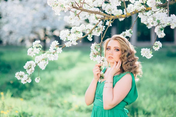 在盛开的花园的苹果树上时尚漂亮的金发女人 — 图库照片