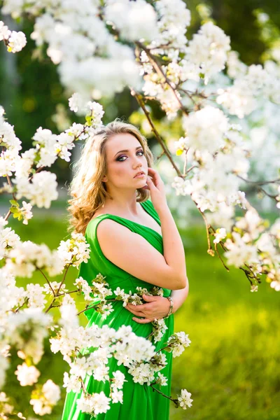 Belle jeune femme blonde debout à côté d'un pommier en fleurs — Photo