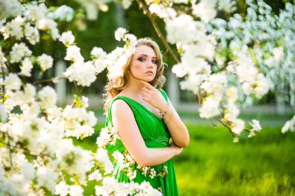 Beautiful happy young woman in spring blossoming garden — Stock Photo, Image