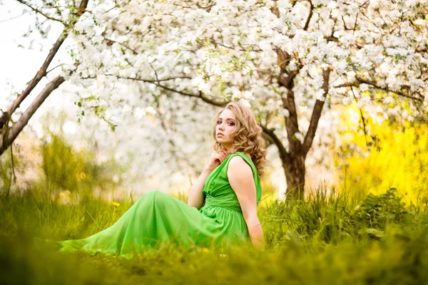 Hermosa mujer rubia de moda en el jardín floreciente de los manzanos — Foto de Stock