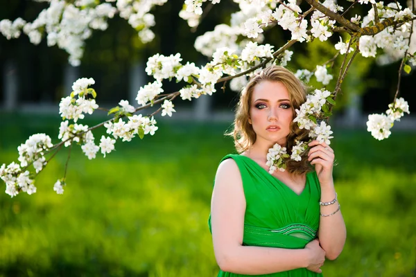 Hermosa mujer rubia de moda en el jardín floreciente de los manzanos — Foto de Stock