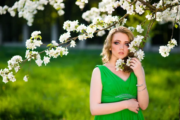 Hermosa mujer rubia de moda en el jardín floreciente de los manzanos — Foto de Stock