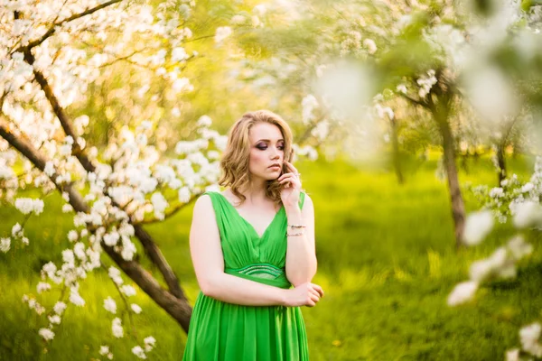 Mulher jovem feliz bonita no jardim florescente de primavera — Fotografia de Stock