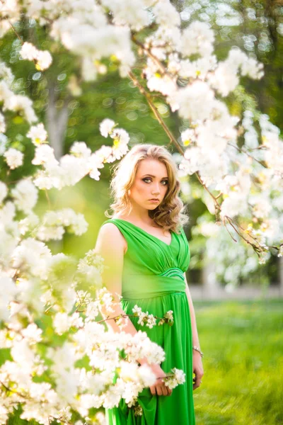 Schöne, glückliche junge Frau im frühlingshaft blühenden Garten — Stockfoto