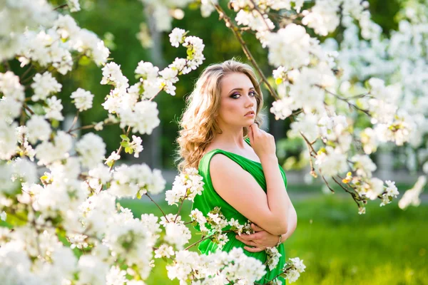 Beautiful happy young woman in spring blossoming garden — Stock Photo, Image