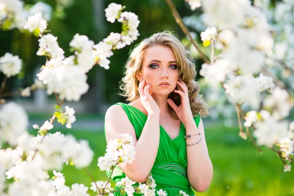 Hermosa mujer rubia de moda en el jardín floreciente de los manzanos — Foto de Stock