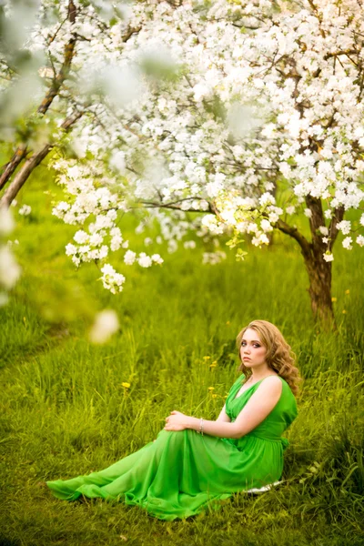 Vacker glad ung kvinna i vår blommande trädgård — Stockfoto