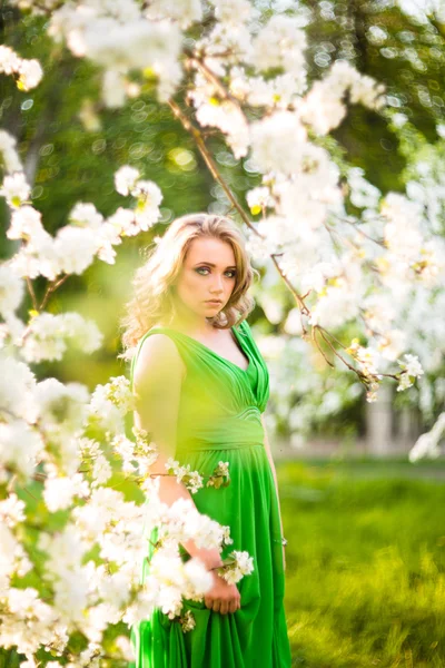 Fashion beautiful blonde woman in blossoming garden of Apple trees Royalty Free Stock Images