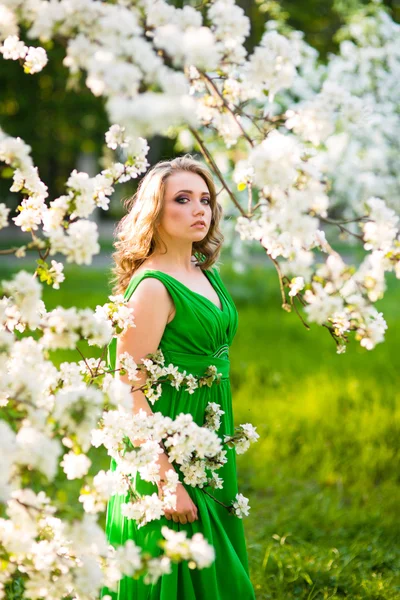 Beautiful happy young woman in spring blossoming garden Royalty Free Stock Photos