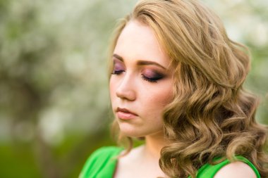 Şu yeni gelişen bir elma ağacı duran güzel genç sarışın kadın