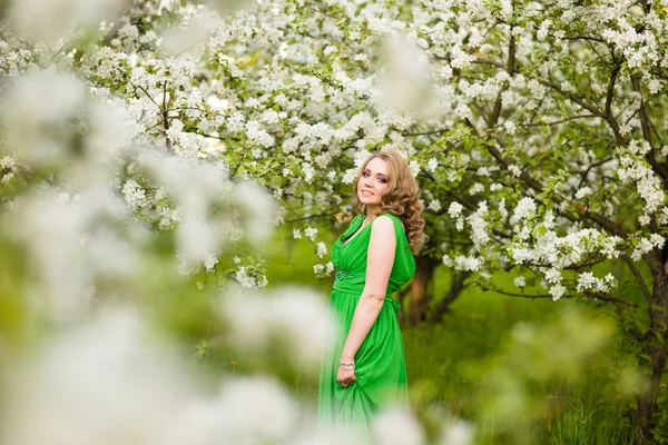 Mulher jovem feliz bonita no jardim florescente de primavera — Fotografia de Stock