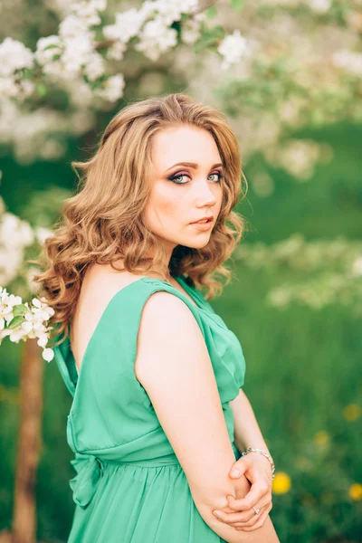 Mulher jovem feliz bonita no jardim florescente de primavera — Fotografia de Stock