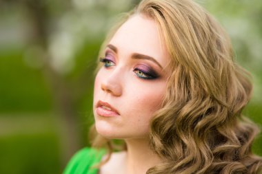 Şu yeni gelişen bir elma ağacı duran güzel genç sarışın kadın