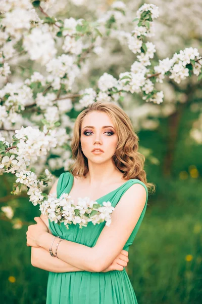 Hermosa mujer joven feliz en el jardín floreciente primavera — Foto de Stock