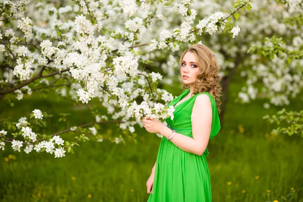 Schöne, glückliche junge Frau im frühlingshaft blühenden Garten — Stockfoto