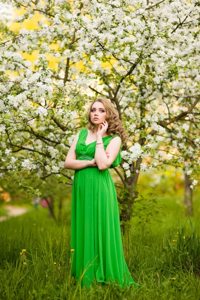 Módní krásná světlovlasá žena v kvetoucí zahradě z jabloní — Stock fotografie