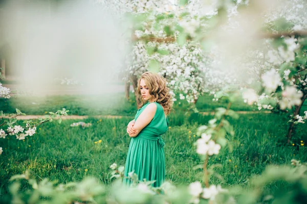 Mulher jovem feliz bonita no jardim florescente de primavera — Fotografia de Stock