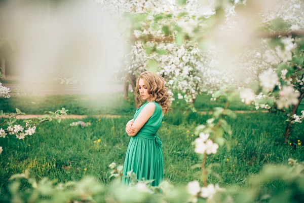 Szép fiatal szőke nő egy virágzó Alma-fa mellett állt — Stock Fotó