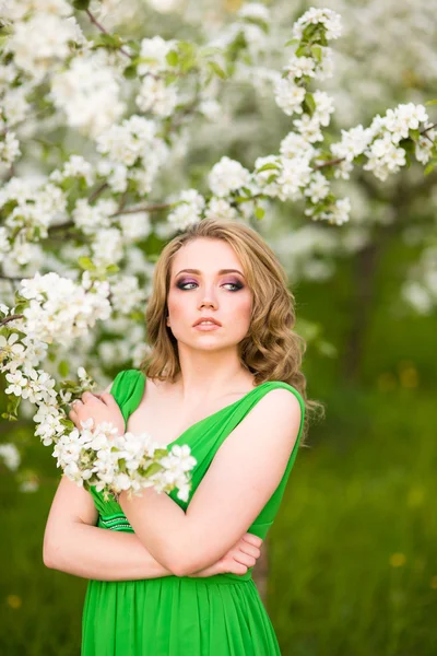 Mulher jovem feliz bonita no jardim florescente de primavera — Fotografia de Stock