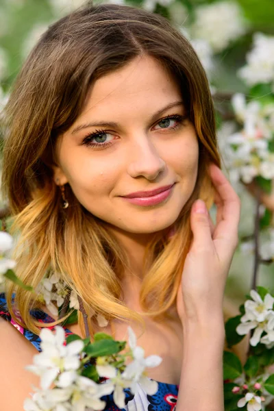 Mooie vrouw in de bloeiende tuin — Stockfoto