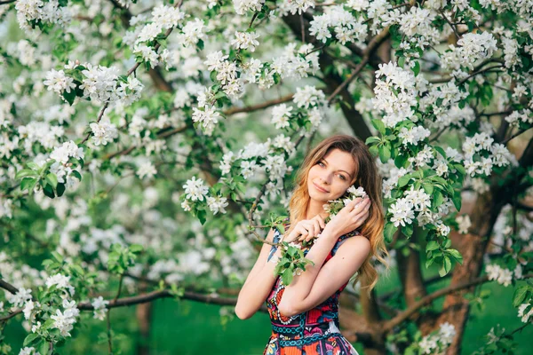 꽃이 만발한 정원의 사과 나무에 아름 다운 금발의 여 자가 패션 — 스톡 사진