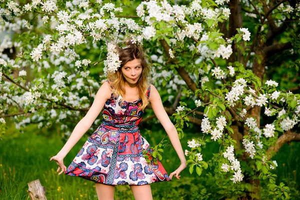 Mooie blonde vrouw in een bloeiende tuin van appelbomen mode — Stockfoto